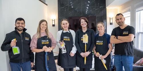 Six Hellamaid staff pose as a group with cleaning tools