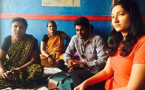 People seated and listening in a pastel coloured room